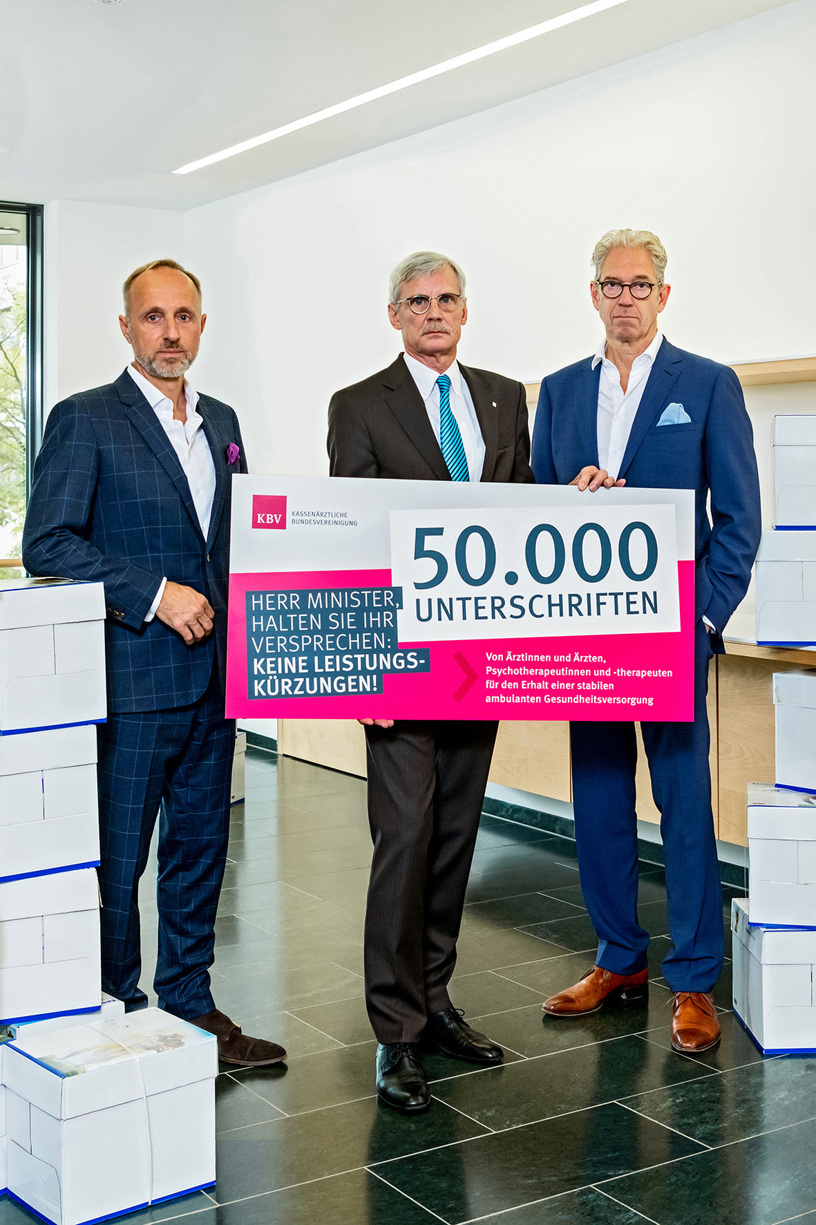 Die KBV-Vorstände Dres. Gassen, Kriedel und Hofmeister (von re. nach li.) einem Schild der Zahl von 50.000 Unterschriften. 