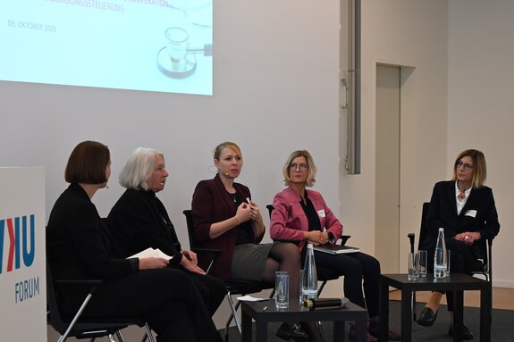 Fünf Personen sitzen in einer Diskussionsrunde.