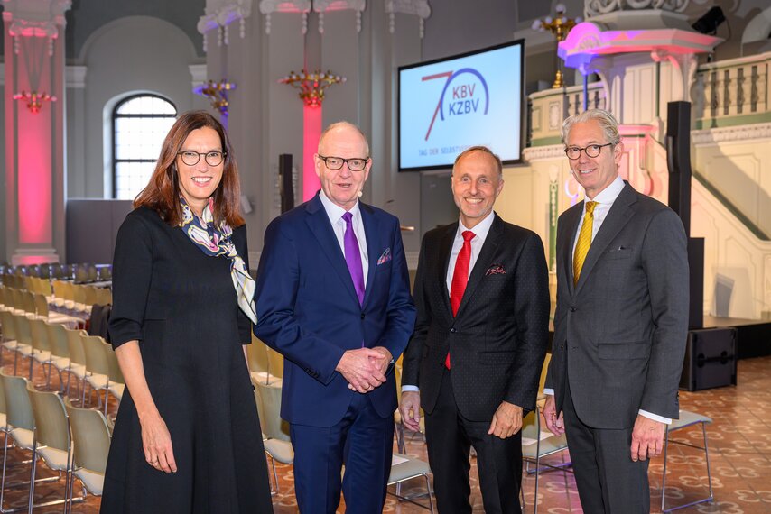 Dr. Sibylle Steiner, Martin Hendges, Dr. Stephan Hofmeister und Dr. Andreas Gassen stehen in einem Saal und lächeln in die Kamera.