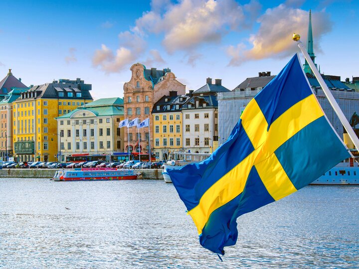 Schwedische Fahne vor Skyline Stockholm