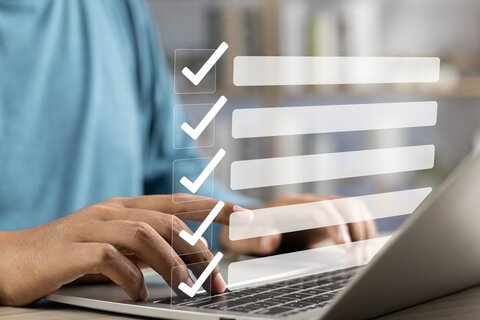 Geschäftsmann mit Laptop und einer digitalen Checkliste