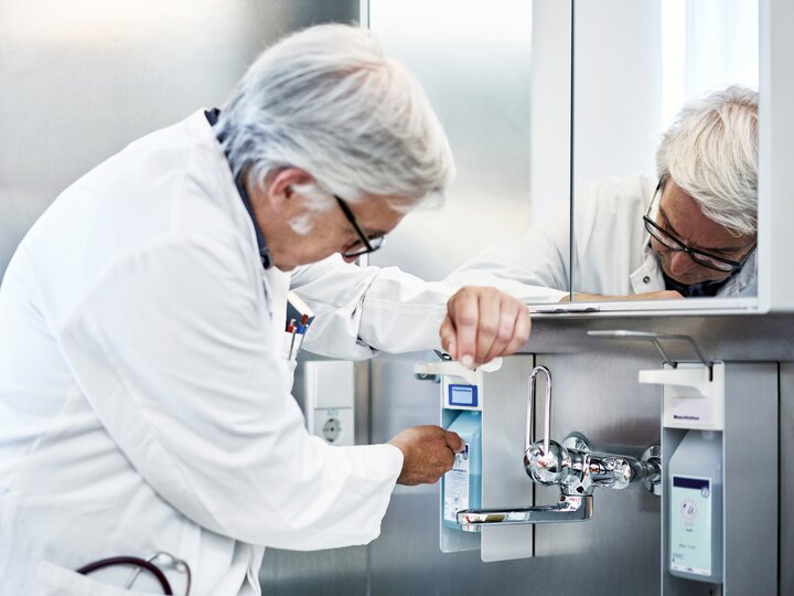  Arzt bei der Desinfektion der Hände 